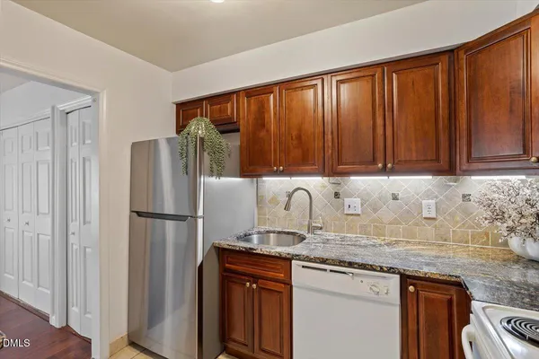 a kitchen with a refrigerator sink and cabinets