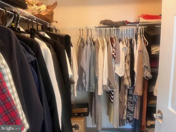 a view of walk in closet with clothes and shoes