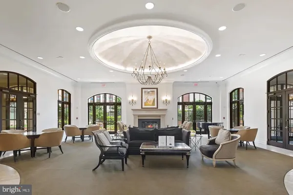 a living room with furniture a chandelier and a dining table