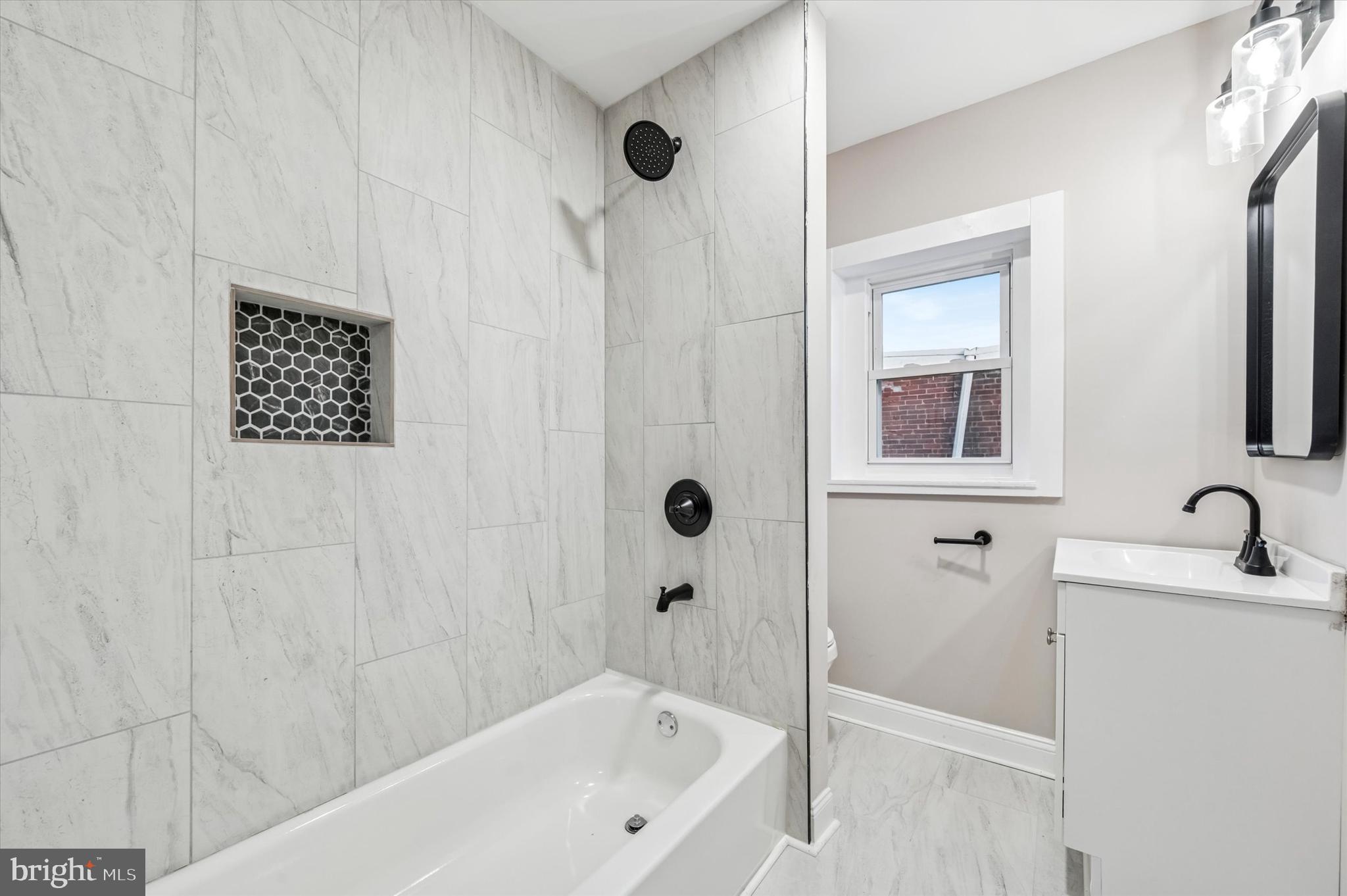 5614 Haverford Avenue Philadelphia, PA 19131 - Photo 15 of 19 a bathroom with a tub a sink and a window