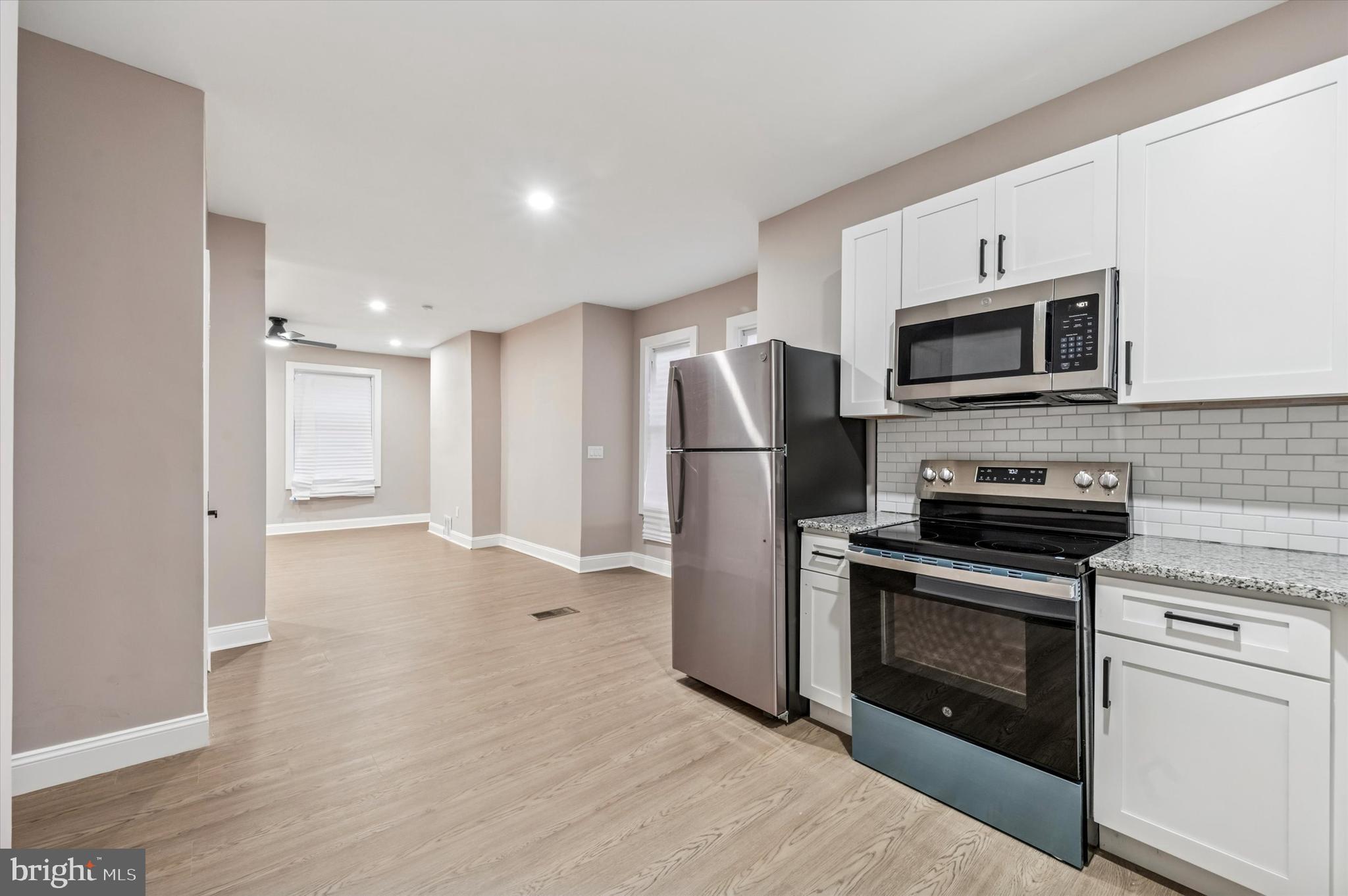 5614 Haverford Avenue Philadelphia, PA 19131 - Photo 8 of 19 a kitchen with stainless steel appliances granite countertop a stove a microwave and a refrigerator