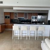 a living room with stainless steel appliances kitchen island granite countertop a table and chairs in it