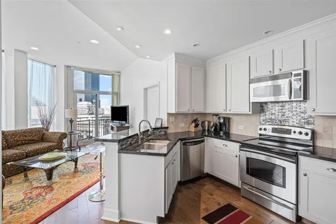 a kitchen with stainless steel appliances a stove sink microwave and cabinets