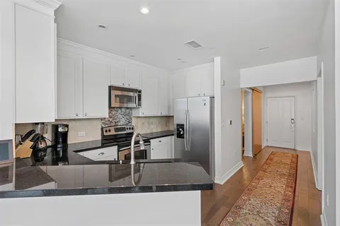 a kitchen with stainless steel appliances granite countertop a refrigerator a stove and a sink