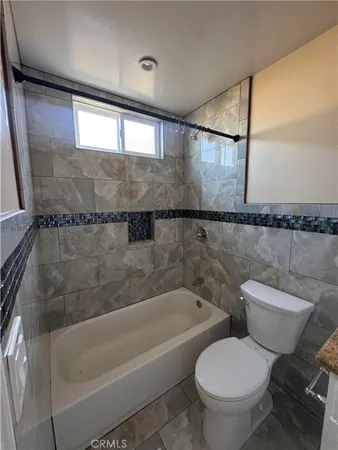 a bathroom with a toilet and a bathtub