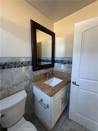 a bathroom with a granite countertop sink and a mirror