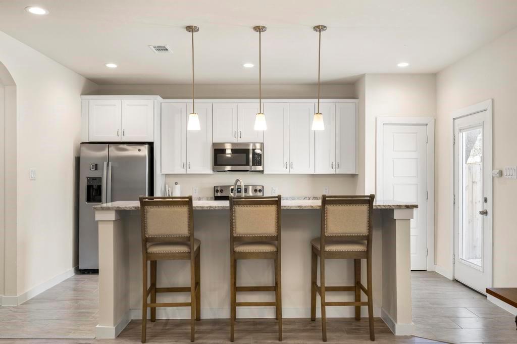 2815 East Overton Road Dallas, TX 75216 - Photo 16 of 23 a kitchen with kitchen island white cabinets and stainless steel appliances