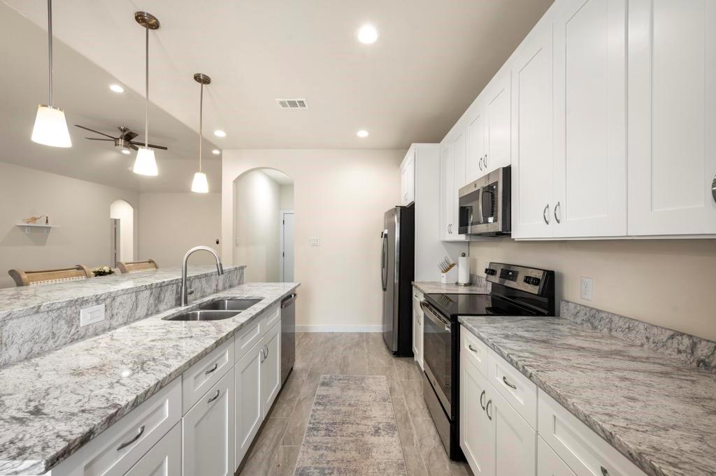 2815 East Overton Road Dallas, TX 75216 - Photo 18 of 23 a kitchen with stainless steel appliances granite countertop a sink a stove and a refrigerator