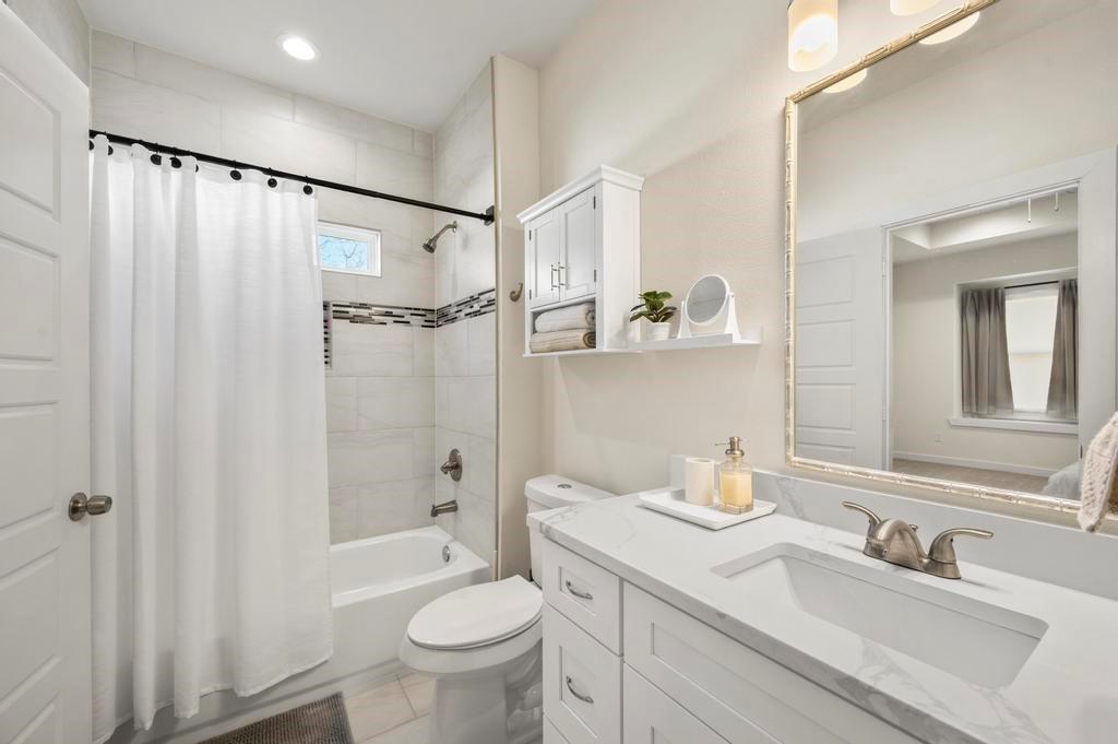 2815 East Overton Road Dallas, TX 75216 - Photo 9 of 23 a bathroom with a sink toilet double vanity and shower