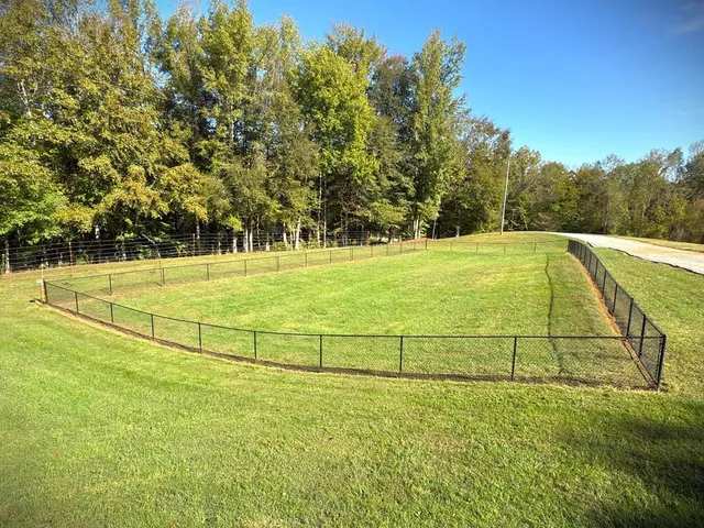a view of a house with a yard and wooden fence