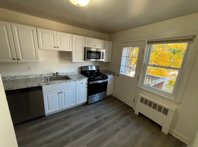 a kitchen with granite countertop a stove a sink and a granite counter tops