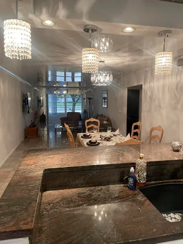 a view of a dining room with furniture and chandelier