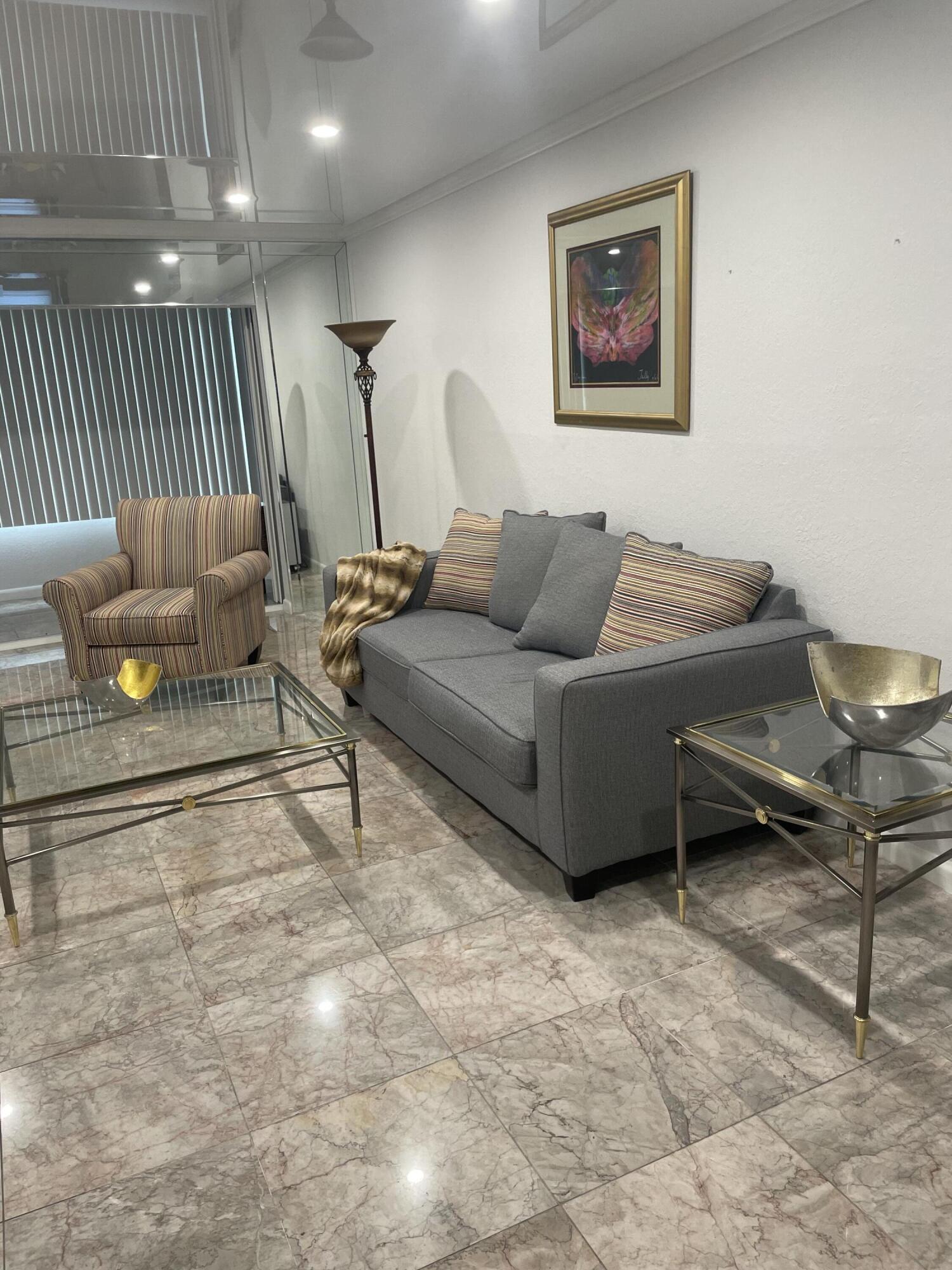 1904 Bermuda Circle, Unit H1 Coconut Creek, FL 33066 - Photo 19 of 72 a living room with furniture a rug and a wall painting