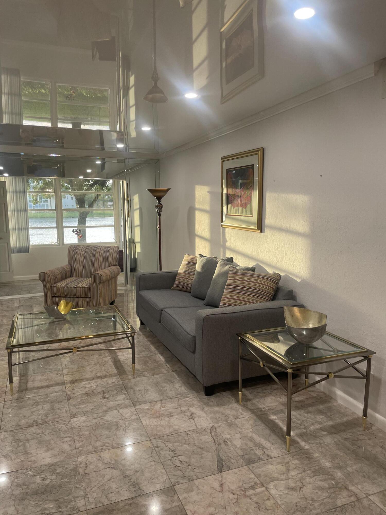 1904 Bermuda Circle, Unit H1 Coconut Creek, FL 33066 - Photo 2 of 72 a living room with furniture and a potted plant