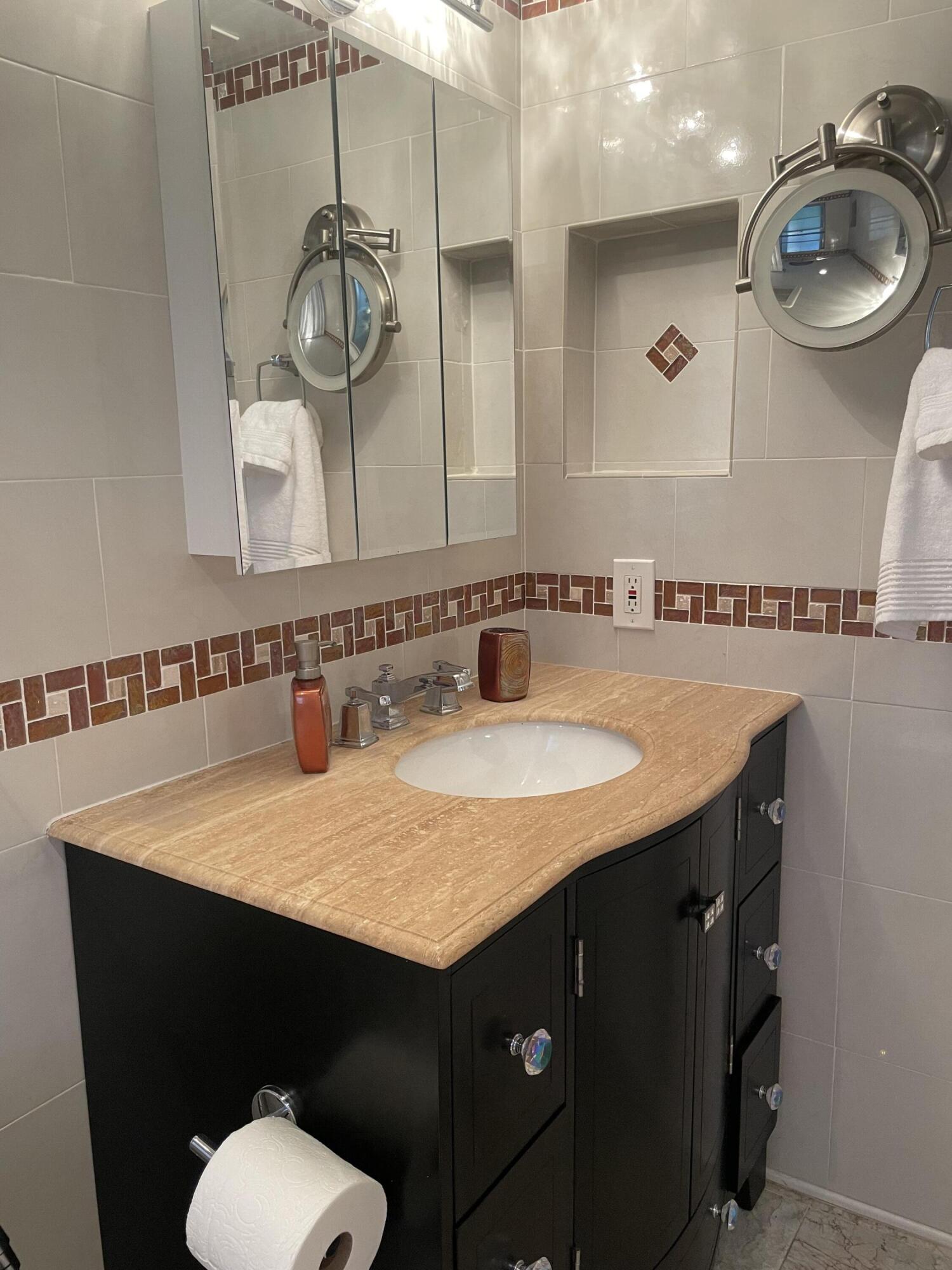 1904 Bermuda Circle, Unit H1 Coconut Creek, FL 33066 - Photo 32 of 72 a bathroom with a sink a toilet and a mirror