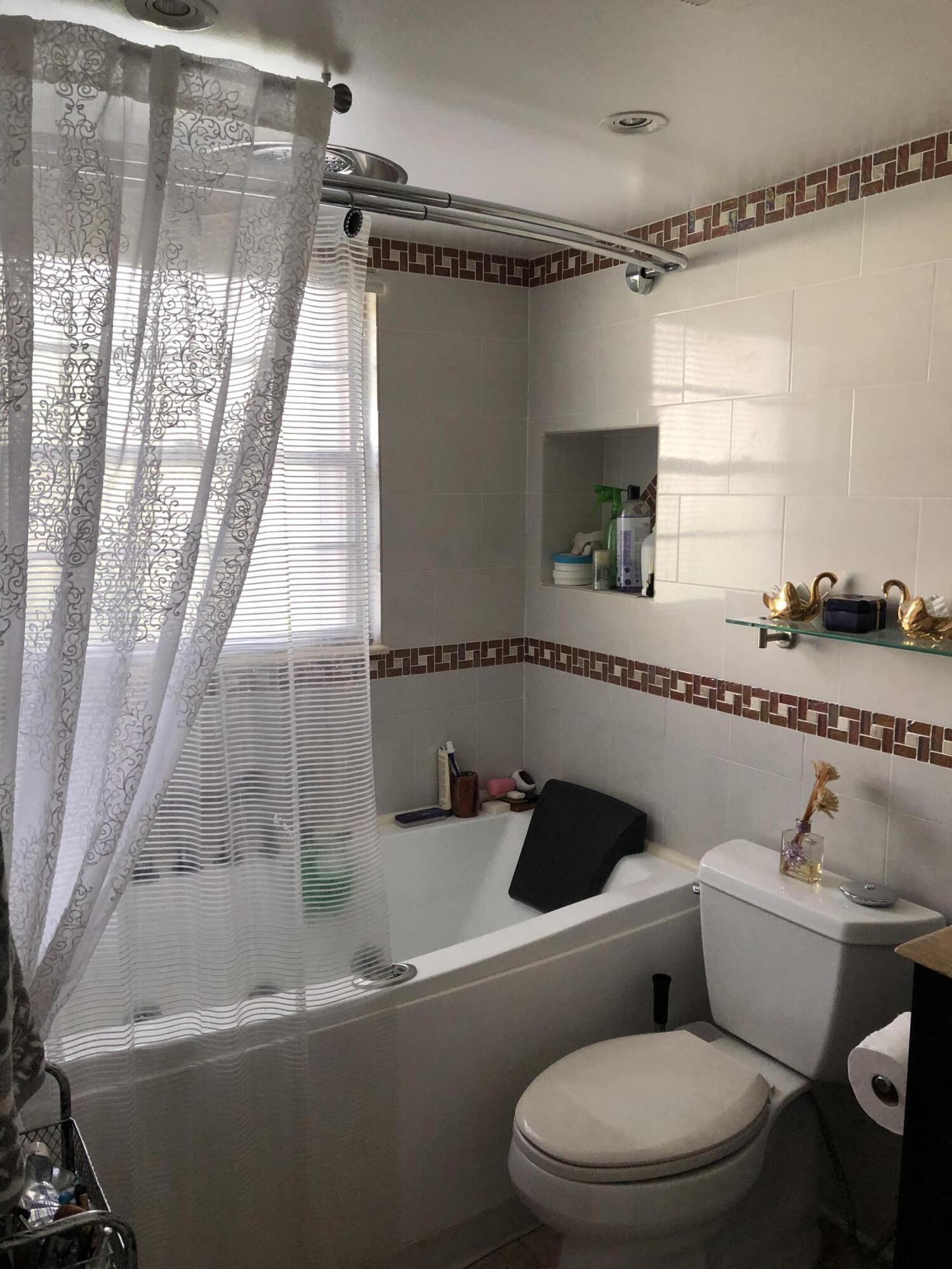 1904 Bermuda Circle, Unit H1 Coconut Creek, FL 33066 - Photo 33 of 72 a white toilet sitting next to a bath tub and shower