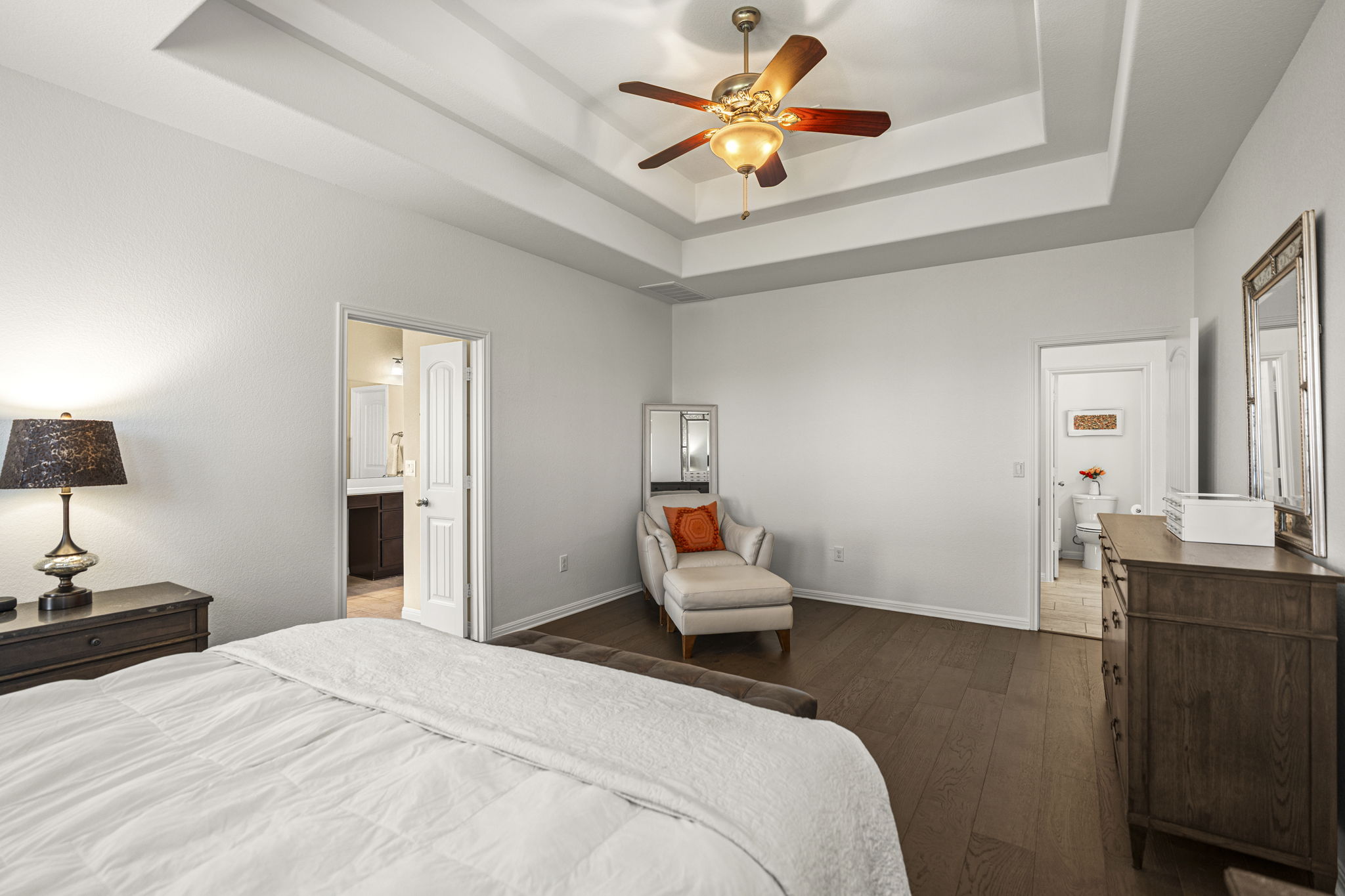 11412 Reading Way Austin, TX 78717 - Photo 12 of 35 Large primary bedroom downstairs with wood flooring and en suite bathroom.