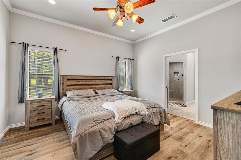 2668 Upper Montague Road Bowie, TX 76230 - Photo 11 of 40 a bedroom with a bed and a chandelier