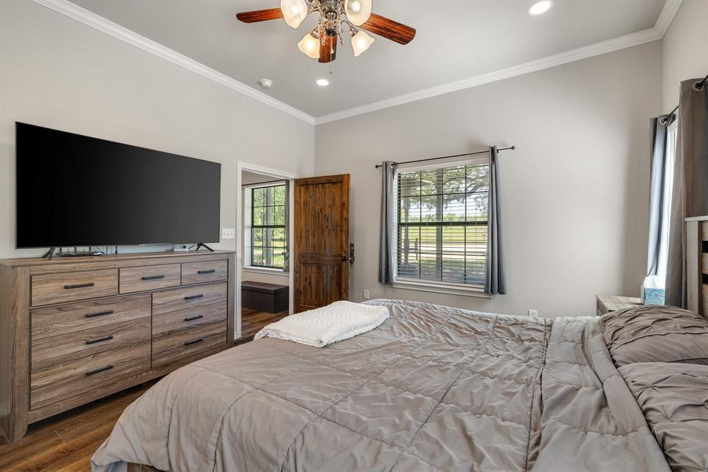 2668 Upper Montague Road Bowie, TX 76230 - Photo 12 of 40 a bedroom with a large bed and a flat screen tv