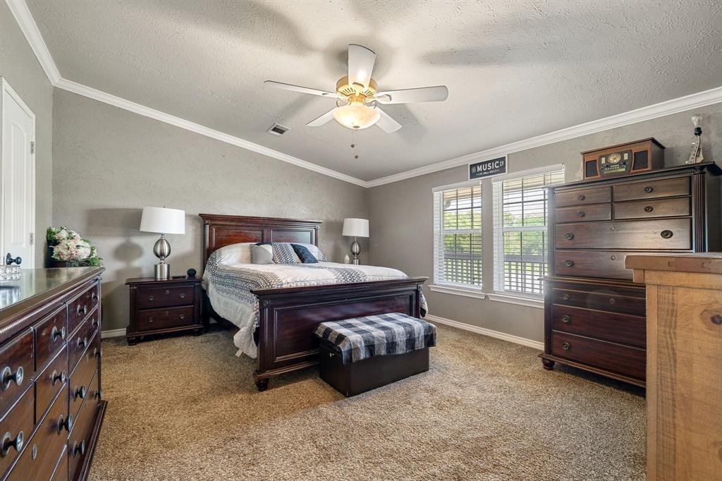 2668 Upper Montague Road Bowie, TX 76230 - Photo 27 of 40 a spacious bedroom with a bed and a chandelier