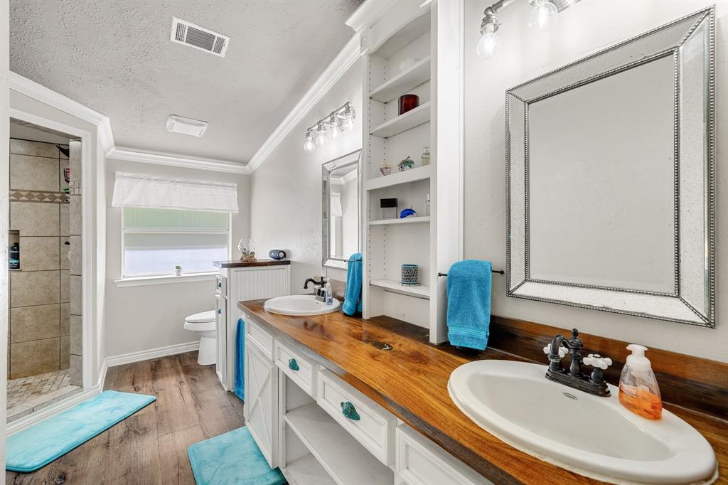 2668 Upper Montague Road Bowie, TX 76230 - Photo 28 of 40 a bathroom with a granite countertop sink and a mirror
