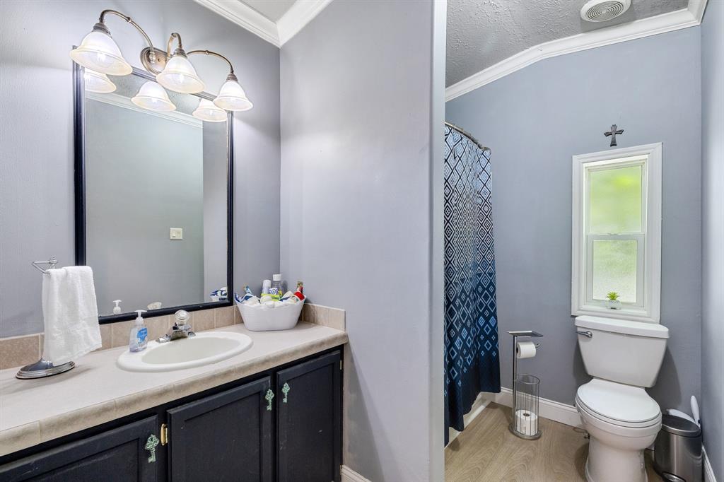 2668 Upper Montague Road Bowie, TX 76230 - Photo 31 of 40 a bathroom with a double vanity sink toilet and a mirror