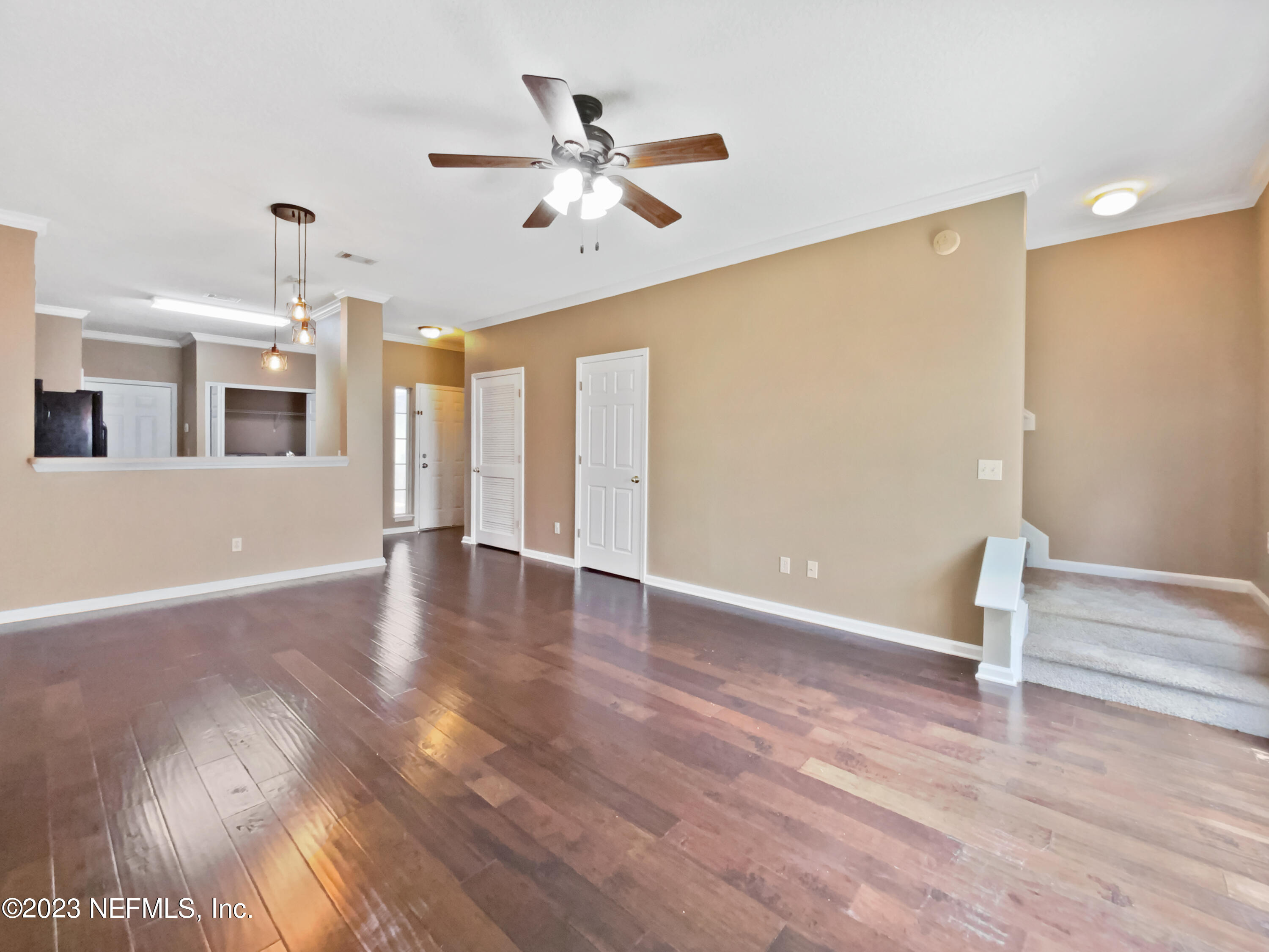 763 Scrub Jay Drive St. Augustine, FL 32092 - Photo 3 of 28 a view of an empty room with wooden floor and a ceiling fan