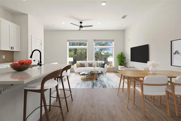 a living room with furniture a flat screen tv and a large window