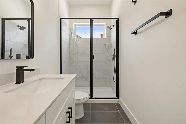 a bathroom with a sink a toilet and shower