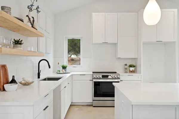 a kitchen with white cabinets and white appliances