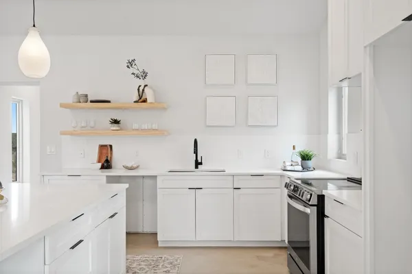 a kitchen with white cabinets stainless steel appliances and sink