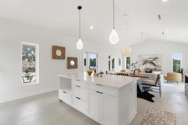 a kitchen with stainless steel appliances a stove a sink and white cabinets with wooden floor