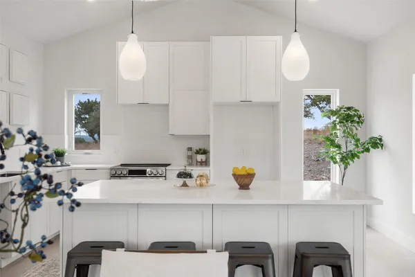 a kitchen with a table a potted plant and cabinets