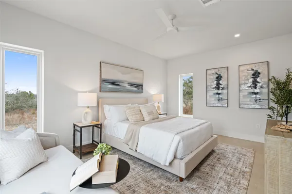 a bedroom with a bed couches and a flat tv screen
