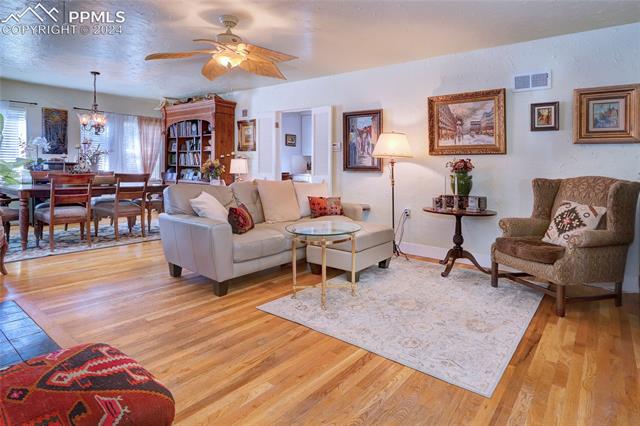 314 West Cheyenne Road Colorado Springs, CO 80906 - Photo 7 of 36 Living room featuring ceiling fan with notable chandelier and light hardwood / wood-style floors
