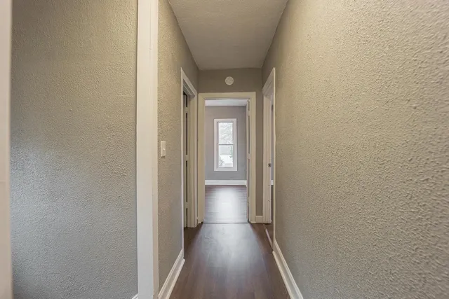 a view of a hallway with wooden floor