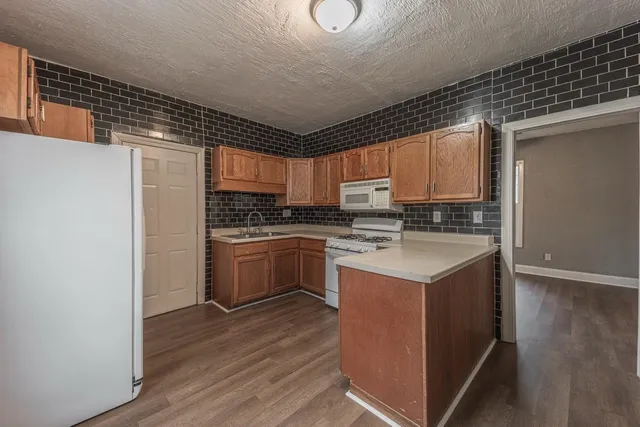 a kitchen with a sink a stove and cabinets