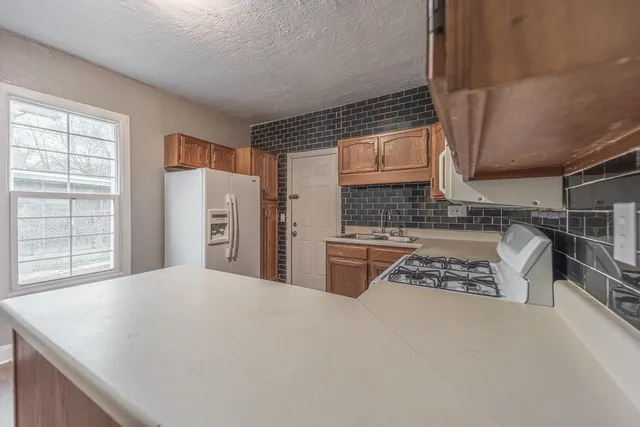 a kitchen with stainless steel appliances kitchen island granite countertop a sink stove and cabinets