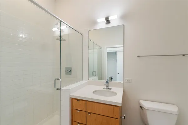 a bathroom with a toilet a sink a mirror and vanity