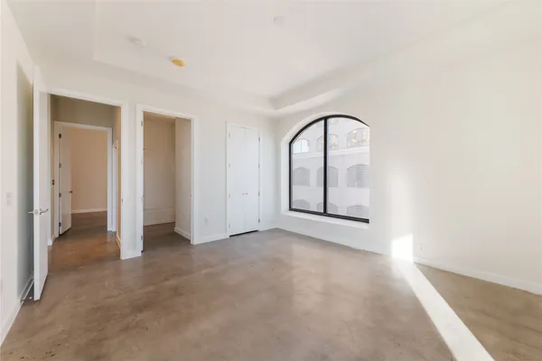 a view of an empty room with closet and a window
