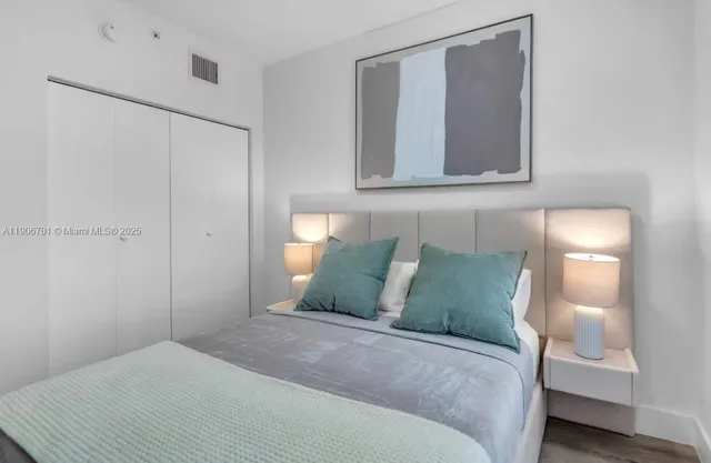 a bedroom with a bed and a painting on the wall