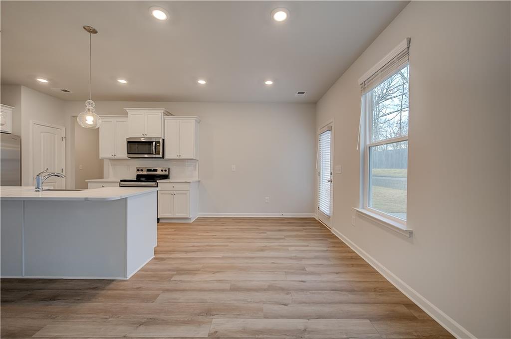 113 St Anne's Place Covington, GA 30016 - Photo 11 of 31 a large kitchen with hardwood floor and a window
