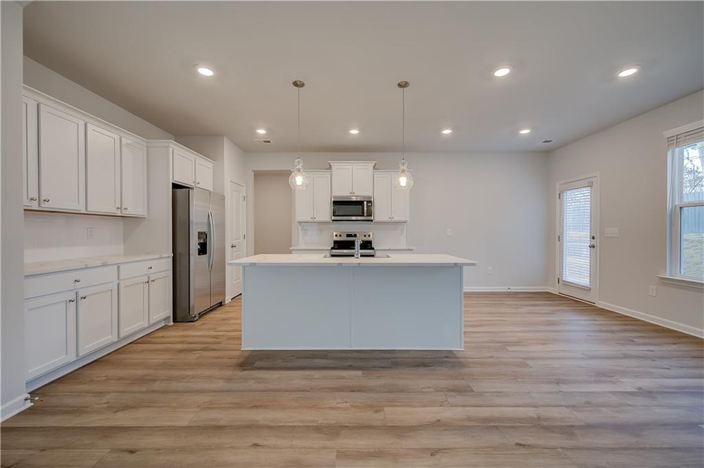 113 St Anne's Place Covington, GA 30016 - Photo 13 of 31 a view of kitchen with kitchen island white cabinets stainless steel appliances and window