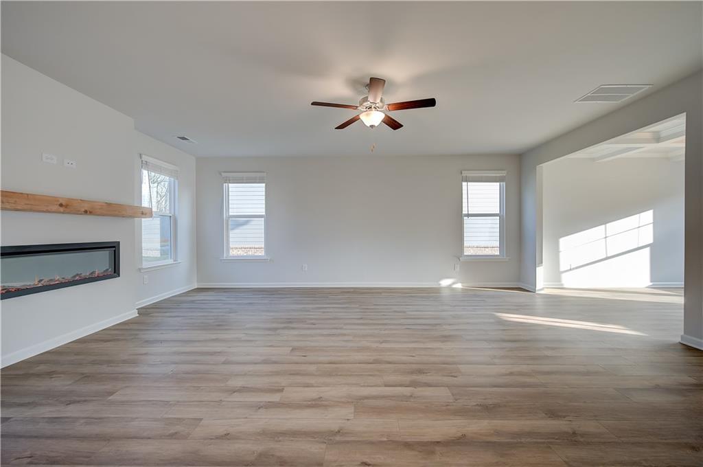 113 St Anne's Place Covington, GA 30016 - Photo 17 of 31 a view of empty room with wooden floor and fan