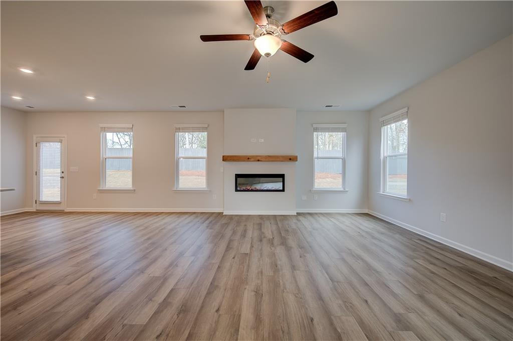 113 St Anne's Place Covington, GA 30016 - Photo 9 of 31 an empty room with wooden floor ceiling fan and windows