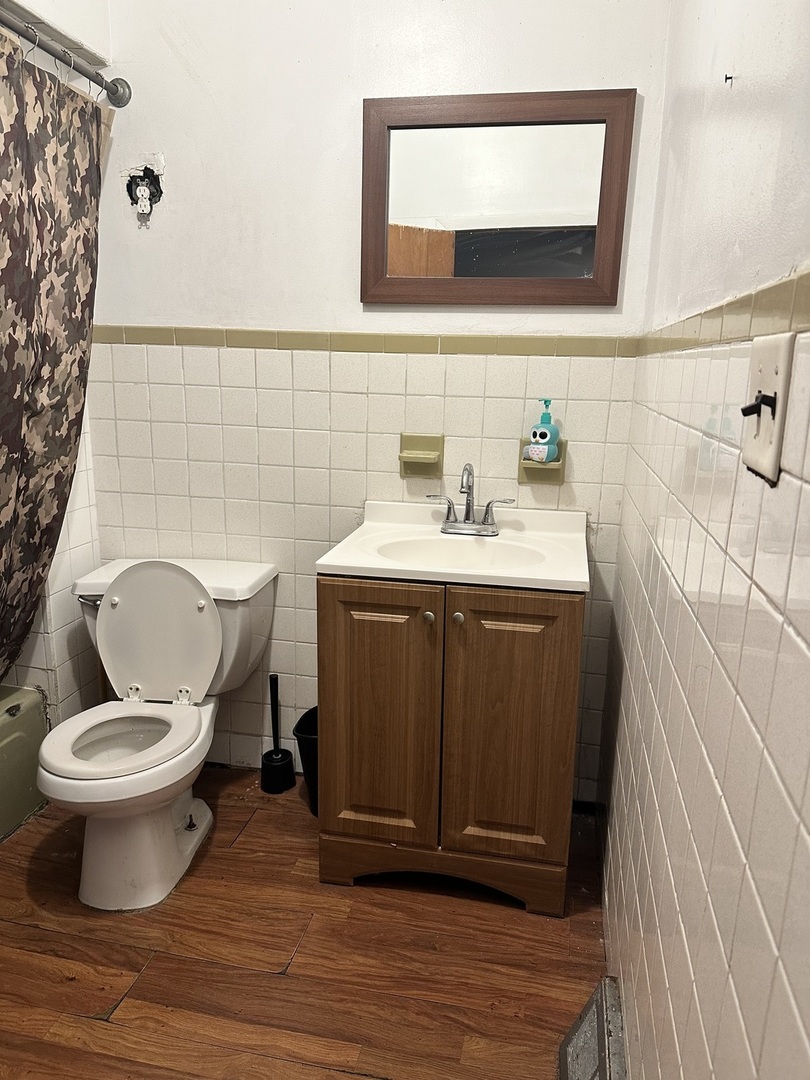 11730 South State Street Chicago, IL 60628 - Photo 4 of 11 a bathroom with a toilet sink and mirror