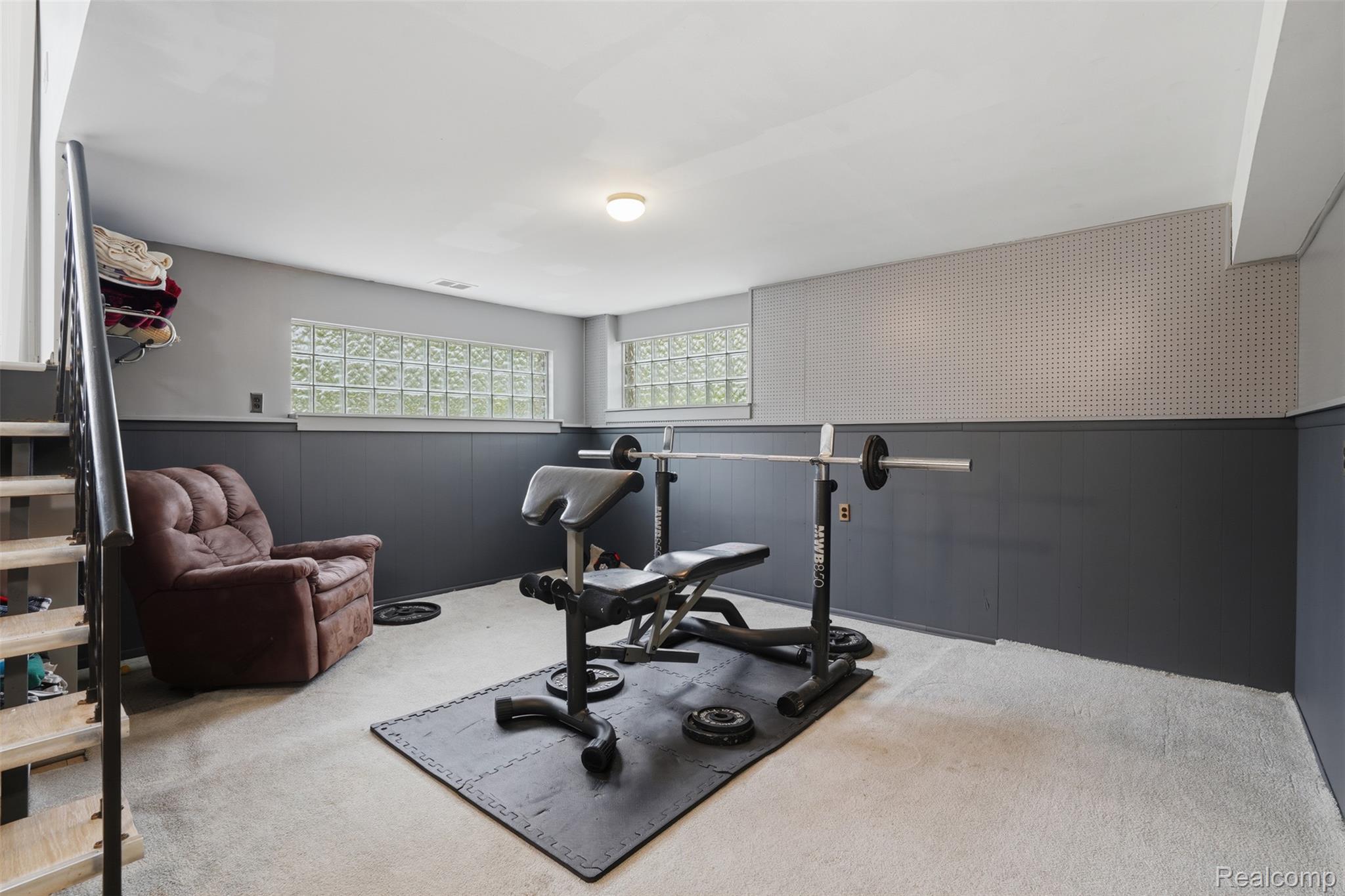47129 Dunsany Road Northville, MI 48167 - Photo 29 of 49 Workout area with a wainscoted wall, light colored carpet, and wooden walls