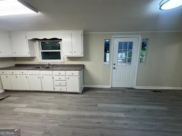 a kitchen with granite countertop a stove a sink and a microwave