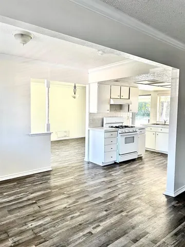a view of a kitchen with a stove cabinets and wooden floor