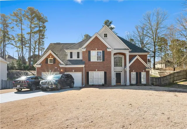 a front view of a house with a yard covered in snow